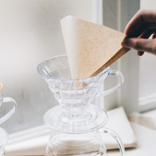 Placing a paper filter into a clear Hario V60 02 dripper
