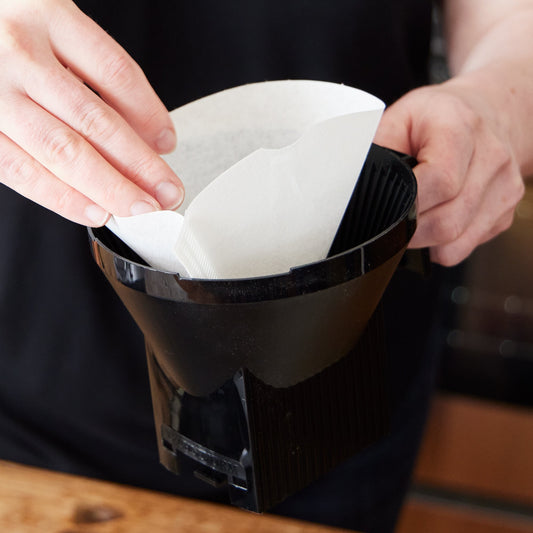 Placing a No.4 paper filter into a Moccamaster brew basket