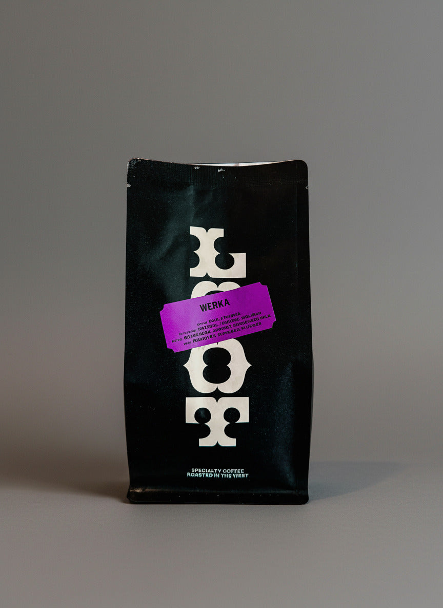 Black coffee bag with a purple label on a white background